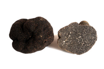 two black truffles, one is sliced